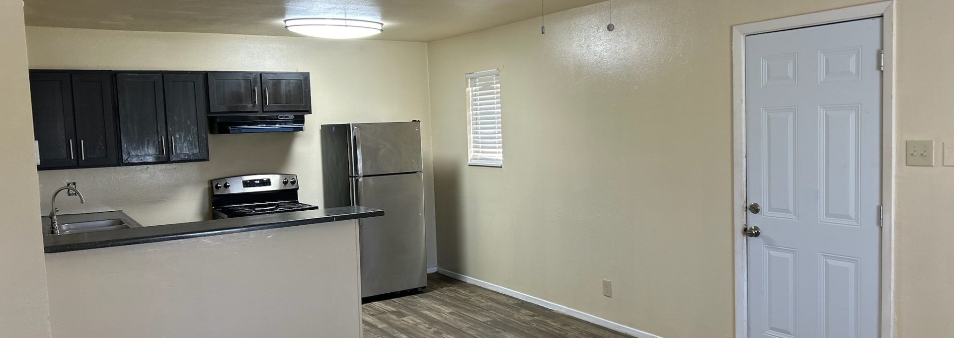 an empty room with a ceiling fan and hardwood floors at The Delmar Place Apartment