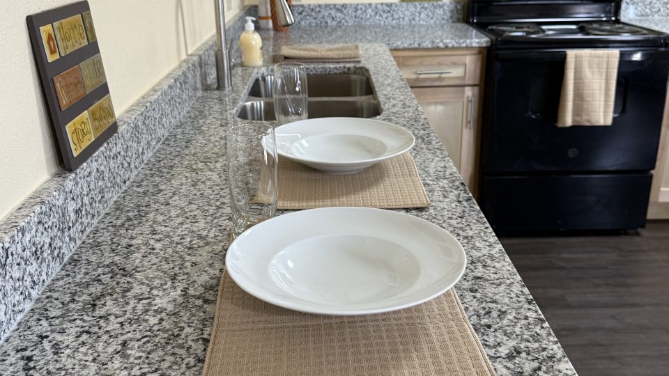 a kitchen with granite counter tops and a sink at The Delmar Place Apartment